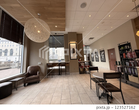 cozy cafe interior featuring stylish furniture, subdued lighting, and a warm, welcoming ambiance ideal for relaxation, conversation, and enjoying a cup of coffee or tea. 123527162