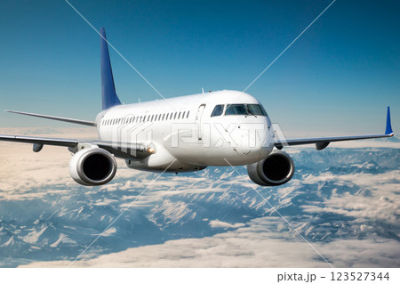 A white passenger aircraft flies above the clouds above the highlands 123527344