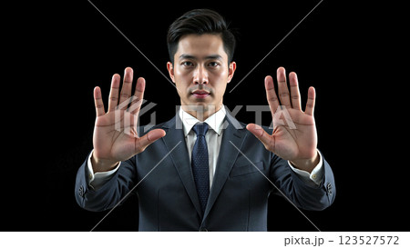 Young businessman showing a stop sign. 123527572