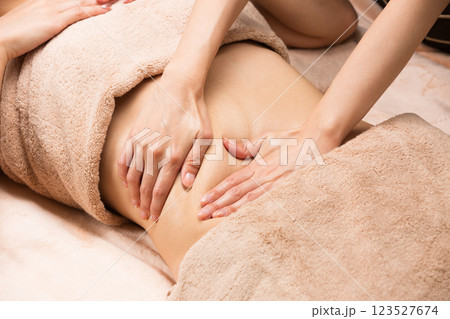 若いアジア人女性はおなかのオイルマッサージを受けている。 123527674
