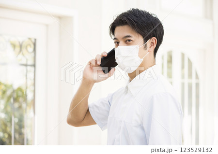 スマホで会話をするマスク姿の介護福祉士、看護師 123529132