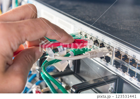 hand of engineer plugging in ethernet cable into server switch p 123531441