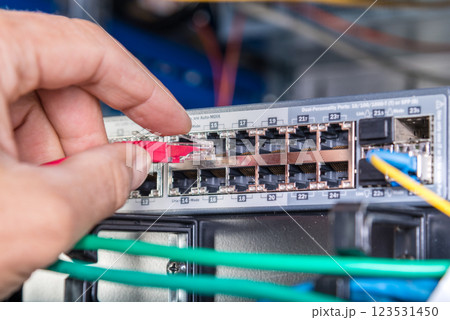 hand of engineer plugging in ethernet cable into server switch p hand of engineer plugging in ethernet cable into server switch p 123531450