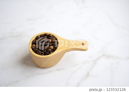 Coffee beans in a large wooden spoon on White Background 123532126