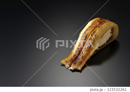 炙り穴子の一本握りを黒背景で撮影 炙り穴子の一本握りを黒背景で撮影 123532261