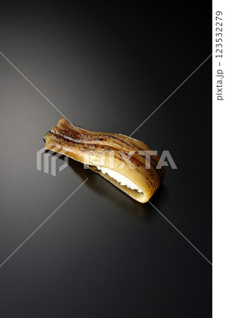 炙り穴子の一本握りを黒背景で撮影 123532279