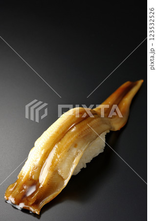 穴子の一本握りを黒背景で撮影 穴子の一本握りを黒背景で撮影 123532526