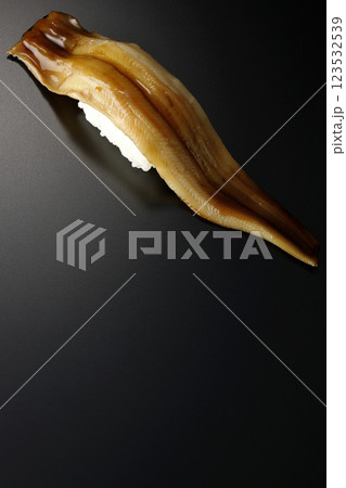 穴子の一本握りを黒背景で撮影 穴子の一本握りを黒背景で撮影 123532539