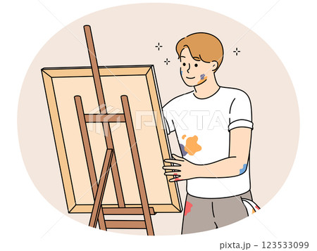 Young man drawing picture on easel 123533099