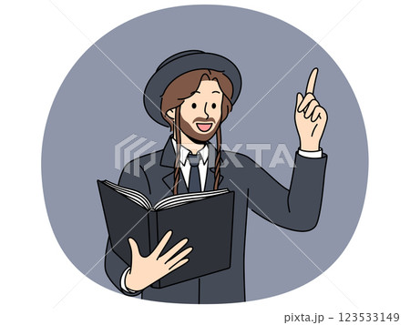 Jewish man holds book with religious texts and points finger up talking about israelite religion Jewish man holds book with religious texts and points finger up talking about israelite religion 123533149