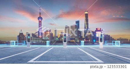 Electric vehicle charging stations illuminating shanghai skyline at dusk 123533301