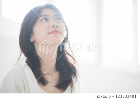 明るい日差しの差し込む窓辺で爽やかな見上げる笑顔の女性 123533481