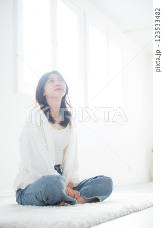 明るい日差しの差し込む窓辺で爽やかな見上げる笑顔の女性 123533482