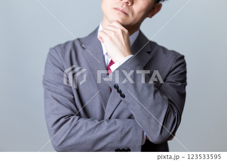 グレーのスーツを着て悩むミドル男性ビジネスマン グレーのスーツを着て悩むミドル男性ビジネスマン 123533595