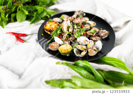 A plate of clams and mussels with herbs, garlic, and chili peppers is a seafood delight. A plate of clams and mussels with herbs, garlic, and chili peppers is a seafood delight. 123533933