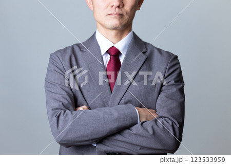 グレーのスーツを着て腕組みをするミドル男性ビジネスマン 123533959