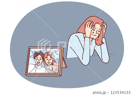 Woman cries after breaking up with husband and is sad sitting near broken photo with happy family Woman cries after breaking up with husband and is sad sitting near broken photo with happy family 123534133
