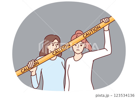 Women near yellow caution tape prohibiting passage to crime scene or territory closed to strangers 123534136
