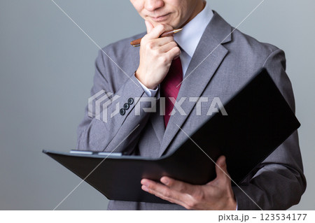 資料を見て悩むミドル男性ビジネスマン 123534177