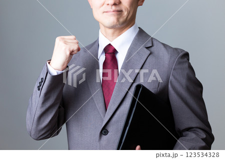 書類を持って笑顔でガッツポーズをするミドル男性ビジネスマン 123534328