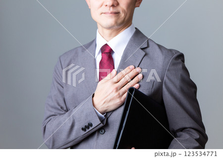書類を持って笑顔で胸に手を当てるミドル男性ビジネスマン 書類を持って笑顔で胸に手を当てるミドル男性ビジネスマン 123534771
