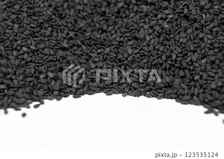 Black sesame seeds scattered on a white background place for text Black sesame seeds scattered on a white background place for text 123535124