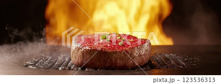 Sizzling juicy steak grilling with flames and smoke creating dramatic lighting effects Sizzling juicy steak grilling with flames and smoke creating dramatic lighting effects 123536313