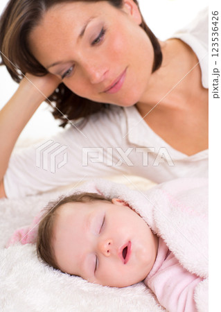 Baby girl sleeping with mother care near 123536426