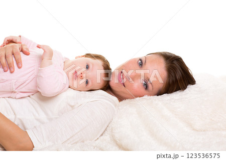 Baby girl and mother lying happy together on white fur 123536575