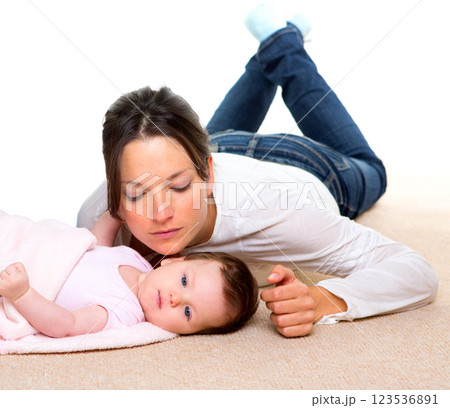 Baby and mother lying on beige carpet together 123536891