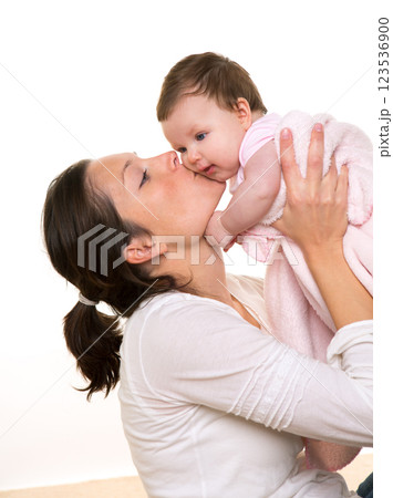 Beautiful mother kissing baby girl hug on white 123536900
