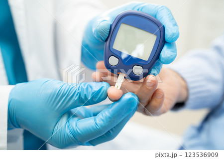 Doctor check diabetes from finger blood sugar level with finger lancet. Doctor check diabetes from finger blood sugar level with finger lancet. 123536909