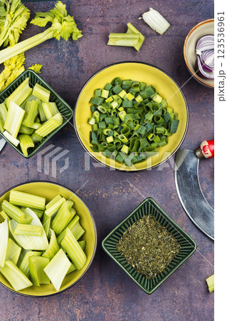 Cut celery sticks and leaves on table. Cut celery sticks and leaves on table. 123536961