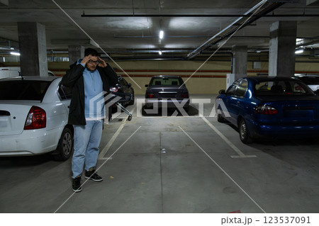 Person in Underground Parking Garage Figure Out of Stolen Car 123537091