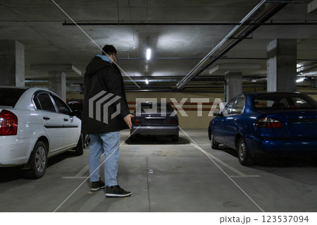 Person in Underground Parking Garage Figure Out of Stolen Car 123537094