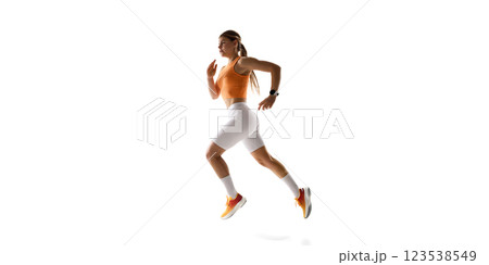 Female athlete sprinting forward, demonstrating fitness, agility, and strength against white studio background. 123538549