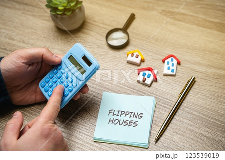 Flipping houses concept. Process of buying a property, renovating it, and then selling it for a profit. Notes with inscription and calculator in the hands of a businessman. Real estate and business 123539019