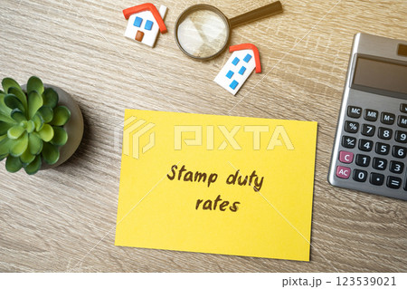 Stamp duty rates concept. Taxes assessed during the transfer of real estate between two parties. Buying housing and land. Property. Stamp Duty Land Tax SDLT. notes and houses with calculator 123539021