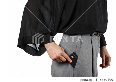 Modern business woman putting black premium credit bank card in grey pants pocket on white background. Money finance 123539199