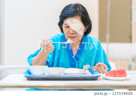 Senior Woman eating food after eye surgery in hospital . Eye disease, Cataract, Glaucoma, Age Related Macular Degeneration, Diabetic Retinopathy, Lasik, World Glaucoma day and health treatment Senior Woman eating food after eye surgery in hospital . Eye disease, Cataract, Glaucoma, Age Related Macular Degeneration, Diabetic Retinopathy, Lasik, World Glaucoma day and health treatment 123539688
