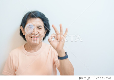 Elderly Woman with eye protective shield after eye surgery. Eye disease, Cataract,  Glaucoma, Age Related Macular Degeneration, Diabetic Retinopathy, Vitreous, Lasik, World Glaucoma day and health 123539698