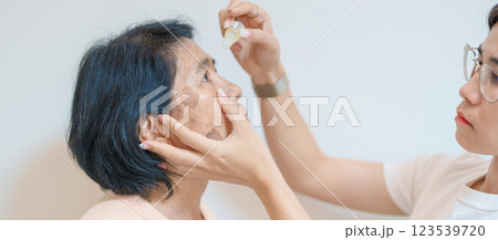 Elderly Woman use ophthalmic solutions or Eye Drops after eye surgery. Eye disease, Cataract,  Glaucoma, Age Related Macular Degeneration, Diabetic Retinopathy, World Glaucoma day and health treatment 123539720