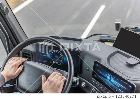 High angle view of driver in the modern cabin of a moving truck. High angle view of driver in the modern cabin of a moving truck. 123540271