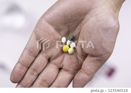 薬を持つ手とコップの水 123540528