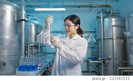 Woman scientist in face mask and glove examining liquid in laboratory 123541533