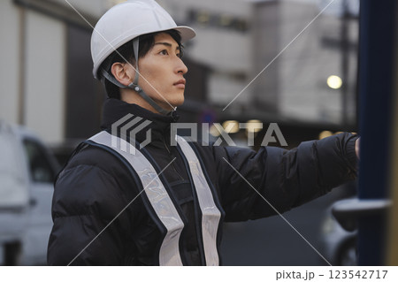 缶コーヒーを飲む作業着の男性 123542717