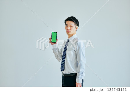 スマホを持つ20代の若い男性　グリーンバック 123543121