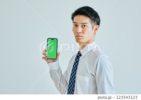 スマホを持つ20代の若い男性 グリーンバック スマホを持つ20代の若い男性 グリーンバック 123543123