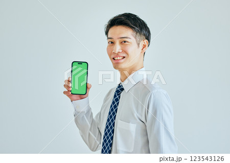 スマホを持つ20代の若い男性　グリーンバック 123543126