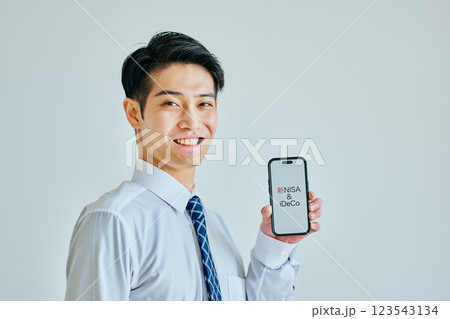 スマホを持つ20代の若い男性 新NISA&iDeCo スマホを持つ20代の若い男性 新NISA&iDeCo 123543134